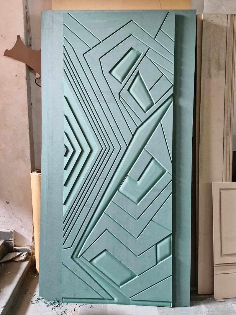 3D CNC door shutter with chamfered geometric relief carved into the face, primed