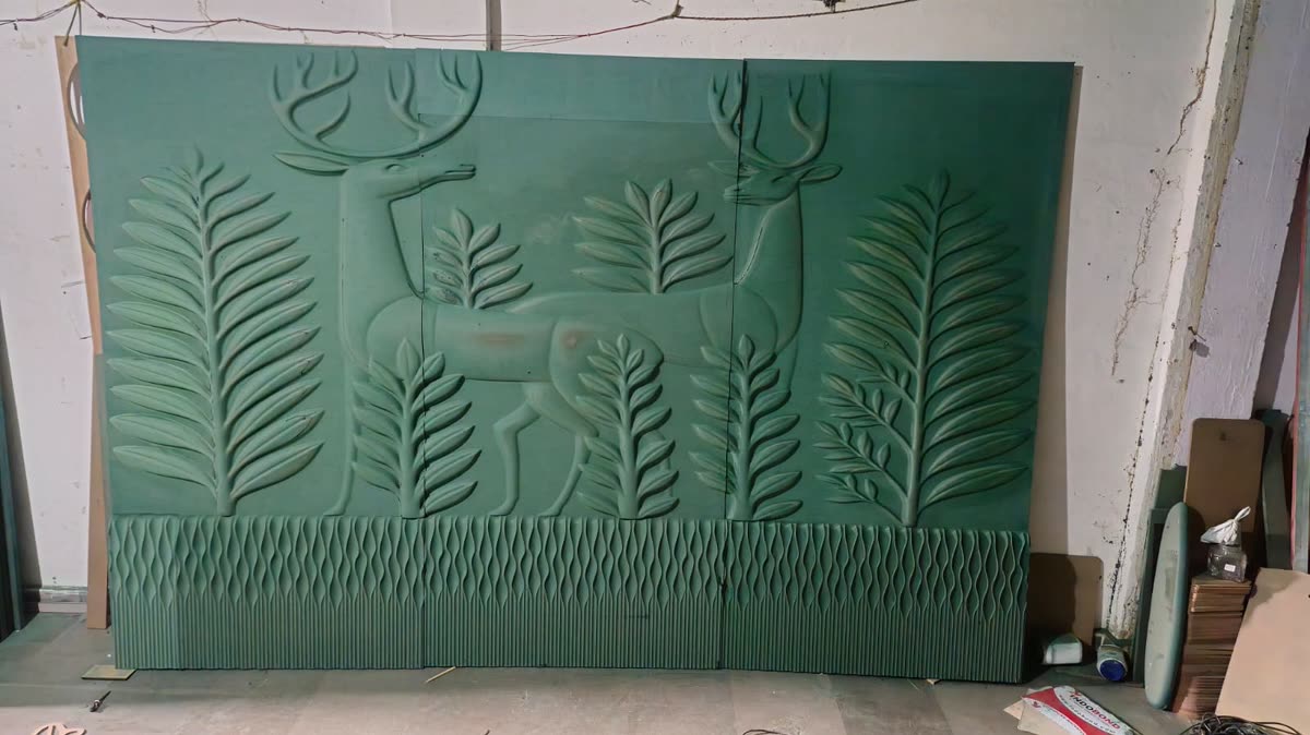 CNC headboard panel with carved deer and fern relief above a fluted base course